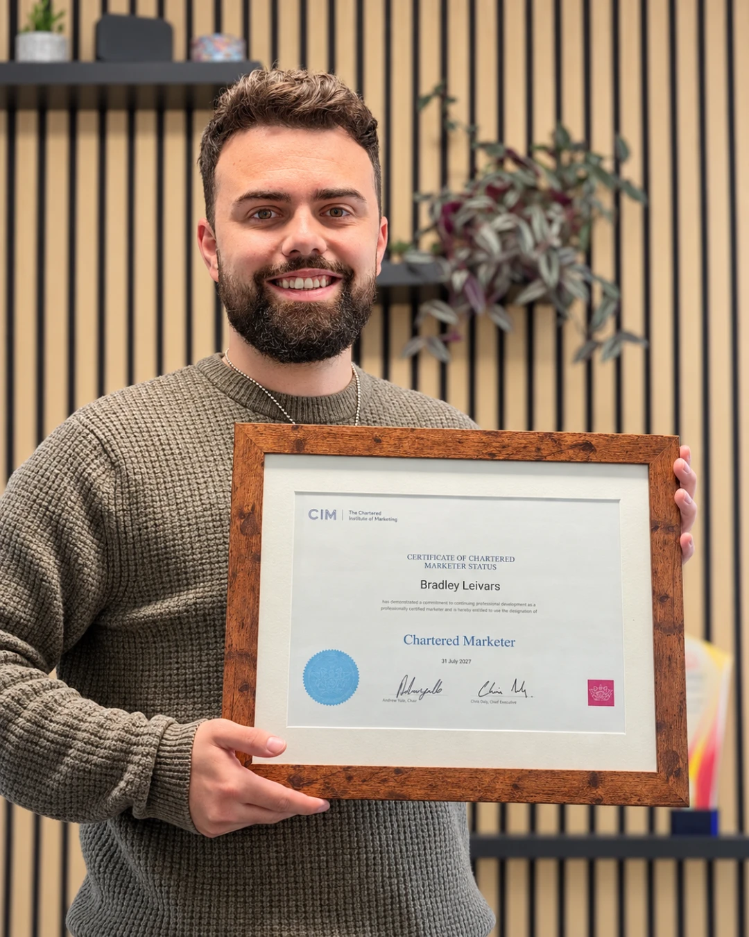 Bradley Leivars, founder of Printlogik, holding his Chartered Marketer certificate