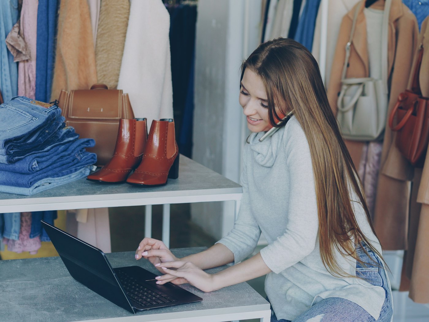A shop owner updating her website on a laptop